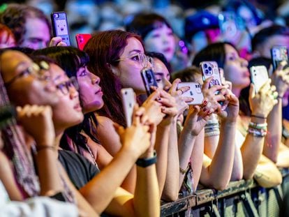Adolescentes usan sus teléfonos mientras Alex G actúa durante un concierto en Nueva York.
