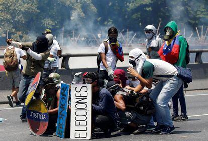 Un grupo de manifestantes opositores choca con la policía durante una protesta contra Nicolás Maduro, este miércoles en Caracas.