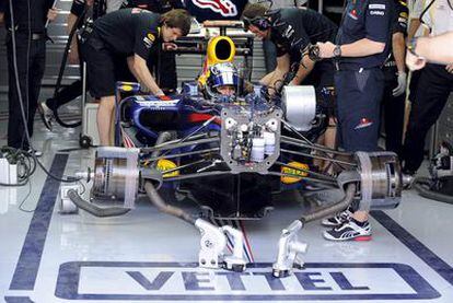 Sebastian Vettel espera en el taller de Red Bull, dentro de su monoplaza, durante los entrenamientos de ayer en Bahrein.