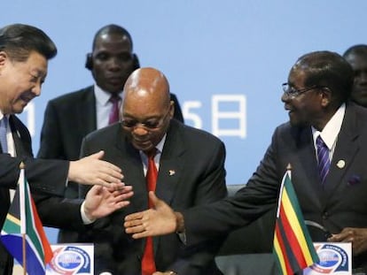 El presidente chino Xi saluda a sus homólogos zimbabuense Robert Mugabe y sudafricano Jacob Zuma en la cumbre de Johanesburgo.