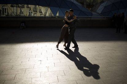 Una pareja argentina proyecta su sombra en el suelo mientras bailan un tango para sacar dinero en la Puerta del Sol de Madrid.