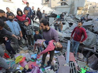 Un hombre saca el cuerpo de un menor de entre los escombros de un edificio bombardeado por Israel en la franja de Gaza.