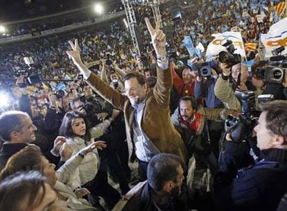 Agachado a la izquierda de Rajoy, El Bigotes, en un mitin en Valencia previo a las elecciones generales.