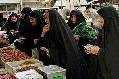 Mujeres iraquíes compran comida en un mercado de Bagdad.