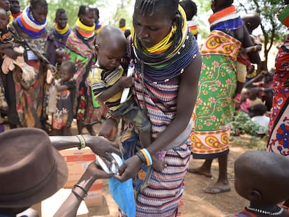 Ekapuan Elipan, promotora de salud comunitaria en Lodakch, Kenia, da a una madre suplementos alimenticios terapéuticos para un niño con desnutrición, el pasado 26 de julio.