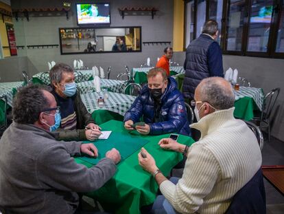 Unos hombres juegan una partida de tute en el interior de un bar tradicional de Madrid.