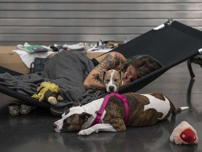 Austun Wilde descansa con sus dos perros en un refugio climatizado en el Centro de Convenciones de Oregón este 27 de junio en Portland, Oregón.