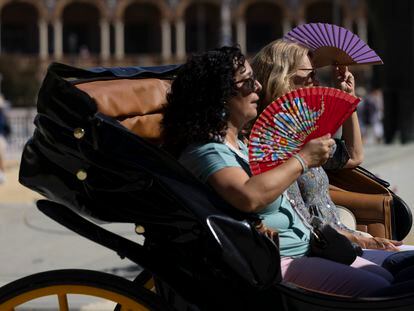 Dos turistas se abanican en una calesa, este jueves en Sevilla, donde se rozaron ya los 37 grados.