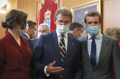 Núñez Feijóo, con una castaña en la mano, junto a Pablo Casado e Isabel Díaz Ayuso, tras la ceremonia de toma de posesión del primero en el Parlamento gallego.