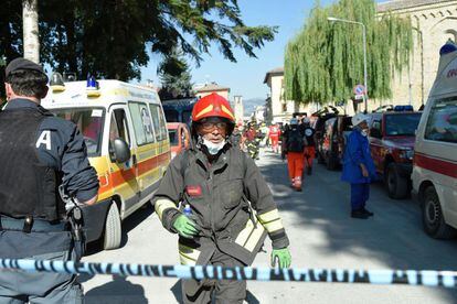 Un bombero camina tras el cordón de seguridad entre los equipos de rescate en el municipio de Amatrice. 