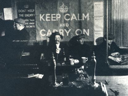 Varios hombres en un pub de Londres, en 1941, con el cartel de 'Keep Calm and Carry On'.