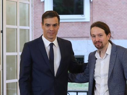 Pablo Iglesias firma el acuerdo sobre el proyecto de ley de presupuestos para 2019 en el Palacio de la Moncloa ante la mirada del presidente, Pedro Sánchez.