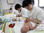 Unas enfermeras cuidan de unos bebés en un centro de infancia de Yongquan, en el sur de China.