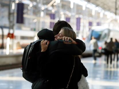 Dos personas se abrazan en la Estación María Zambrano de Sevilla, en la Navidad de 2022.