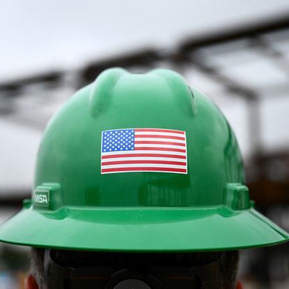 Un obrero exhibe una bandera de EE UU en su casco durante las obras de ampliación del aeropuerto de Los Ángeles