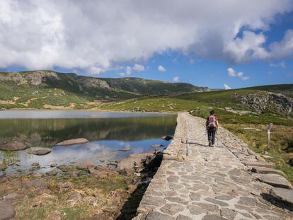 Una mujer camina cruzando la presa de la Laguna de los Peces en Sanabria, Zamora, España.