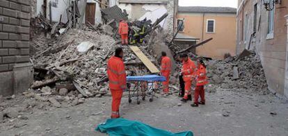 Los servicios de rescate intentan sacar a una víctima de entre los escombros en Onna.