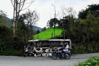 A motorcycle passes in front of a bus burned by members of the Clan del Golfo, near Yarumal, Antioquia, on May 6.