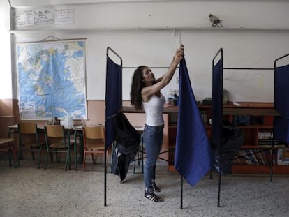 Una funcionària col·loca una cabina en un col·legi a Atenes.