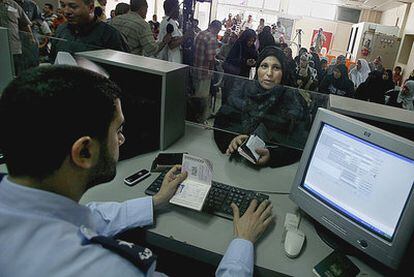 Una palestina entrega su pasaporte a un policía en el puesto fronterizo de Rafah.
