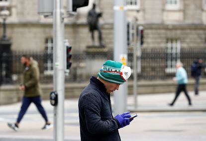 Un hombre consulta su teléfono, este martes en las calles de Dublín.