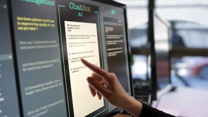 Una trabajadora toca la pantalla de un ordenador para utilizar una aplicación de inteligencia artificial.