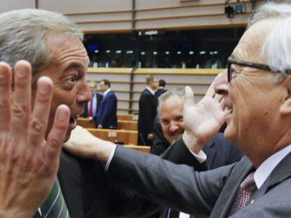 El presidente de la Comisión Europea, Jean-Claude Juncker (d), saluda al líder del Partido de la Independencia de Reino Unido (UKIP), Nigel Farage (i), al inicio de una sesión plenaria extraordinaria del Parlamento Europeo (PE).