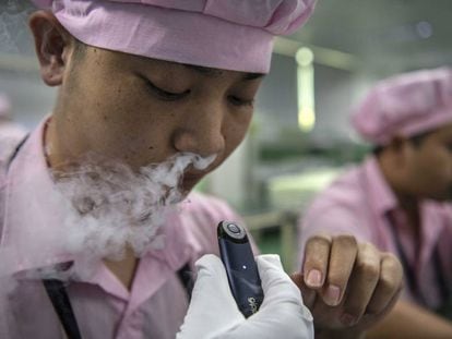 Una trabajadora de la compañía de cigarrillos electrónicos china Kanger Tech prueba el producto en Shenzhen (China).