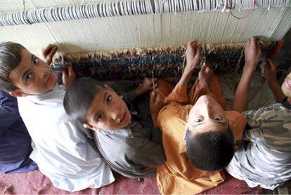 Varios niños afganos trabajan en una fábrica de alfombras en Herat.