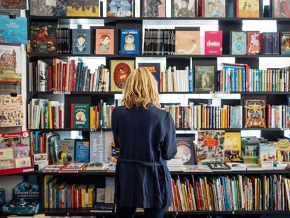 Una mujer observa las estanterías de una librería.
