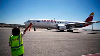 Una empleada de Iberia da el visto bueno a las operaciones en pista de un avión de la aerolínea.
