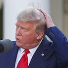 U.S. President Donald Trump holds onto his hair in a gust of wind as he addresses the daily coronavirus response briefing in the Rose Garden at the White House in Washington, U.S., March 30, 2020. REUTERS/Tom Brenner