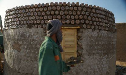 Un hombre saharaui trabaja para terminar una vivienda de botellas en el campamento de Tinduf.