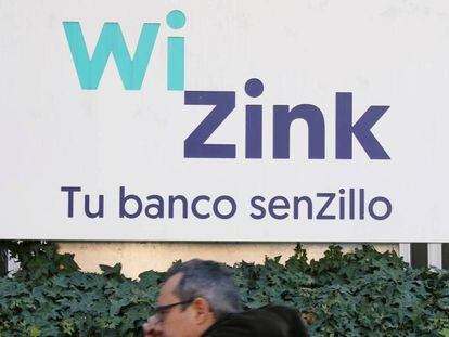 Un hombre pasea delante de un cartel de WinZink