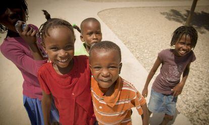 Niños de Port Au Prince saludan a la cámara.