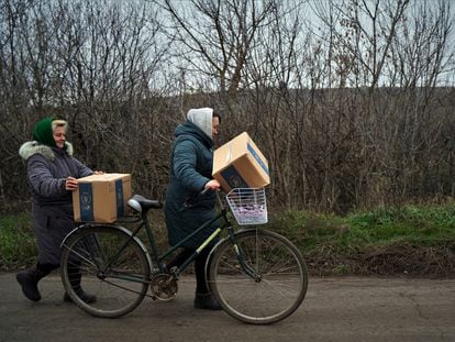 Dos mujeres regresan a casa en Hnilitsia tras recoger raciones de alimentos el pasado 11 de noviembre.