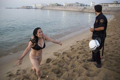 Una chica sale del agua después de las órdenes de un agente.