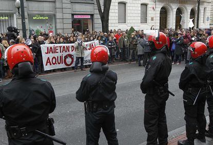 Efectivos de la Ertzaintza a la entrada de un comercio de la Gran Vía de Bilbao ante las protestas de los sindicatos.