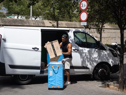 Un repartidor de Amazon organiza los paquetes junto a la furgoneta en el barrio de la Bordeta (Barcelona) en una imagen de archivo de 2022.