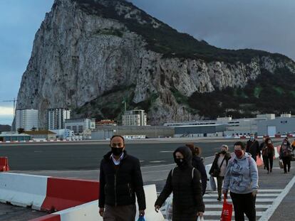 Una fila de personas se dirigen hacia el paso fronterizo entre Gibraltar y España.