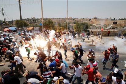 Una multitud de palestinos sale corriendo después de que la policía israelí los atacase con gases lacrimógenos después de la 'Oración del viernes', a las afueras de la Ciudad Vieja de Jerusalén (Israel).