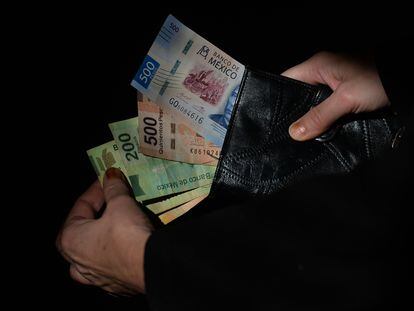 Un ciudadano muestra los pesos mexicanos que lleva en su cartera.