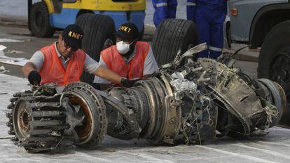 Varios trabajadores inspeccionan un motor recuperado tras el accidente del avión siniestrado el pasado 29 de octubre en el mar de Java, en Indonesia.