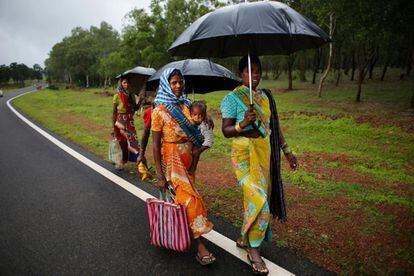 Una mujer tribal amamanta a su bebé mientras camina junto con otras mujeres cerca de Mainpat, en India.