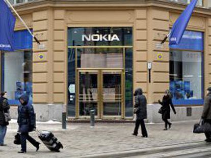 Varios viandantes pasan delante de una tienda que la fabricante de teléfonos móviles Nokia tiene en Helsinki (Finlandia).