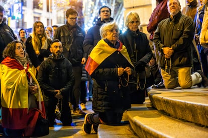 Un grupo de manifestantes se arrodilla durante el rezo de este martes en las protestas contra la amnistía en la calle Ferraz.