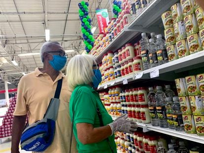 Dos personas con mascarilla compran en un supermercado iraní en Caracas, Venezuela, el 31 de julio.