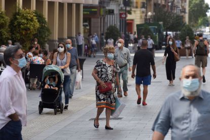 Varias personas con mascarilla caminan por las calles de Huesca este martes.