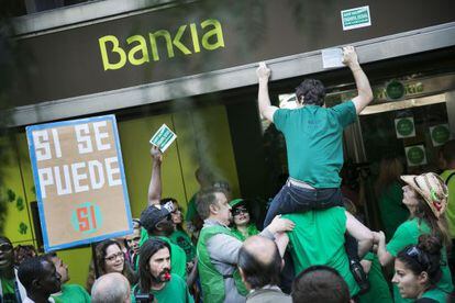 Acitivistas de la PAH protestan en una oficina de Bankia.