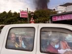 Residents leave their house as lava continues to flow from an erupted volcano, in La Mancha on the island of La Palma in the Canaries, Spain, Friday, Sept. 24, 2021. A volcano in Spain’s Canary Islands continues to produce explosions and spew out lava, five days after it erupted. Two rivers of lava continue to slide slowly down the hillside of La Palma on Friday. (AP Photo/Emilio Morenatti)